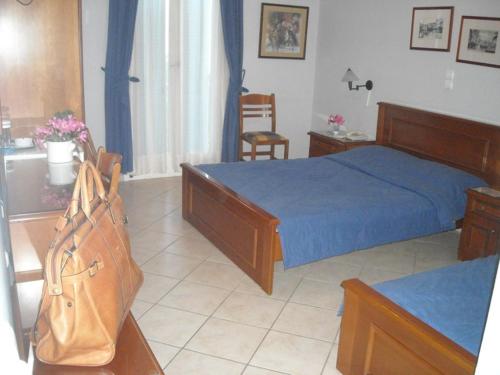 a bedroom with a bed with a blue blanket and a purse at Aegli in Ermoupoli