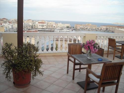 a patio with a table and chairs and a balcony at Aegli in Ermoupoli
