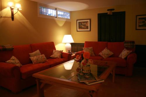 a living room with red couches and a coffee table at La Posada de Quijada in Granada
