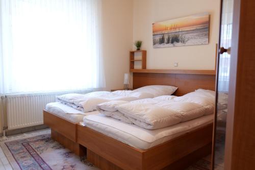 una camera da letto con un letto con cuscini bianchi di Haus Trafalgar App 255 a Cuxhaven
