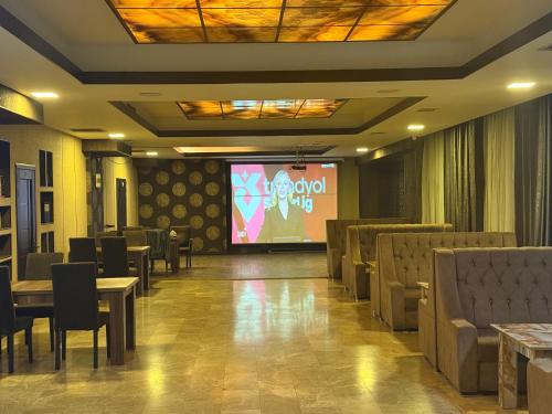 a room with tables and a screen with a presentation at Black Mont İnn Hotel in Baku