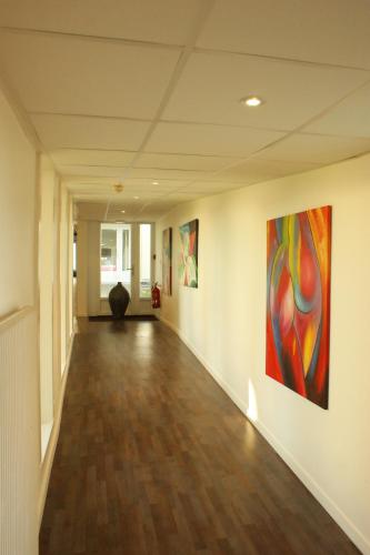 an empty hallway with paintings on the walls at Hotel Val Vert in Pouilly-en-Auxois