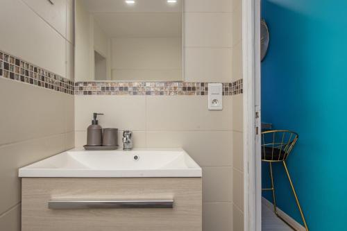 une salle de bain avec un lavabo blanc et un miroir dans l'établissement DOUMER - Cosy deux pièces - Frontière Monaco, à Beausoleil