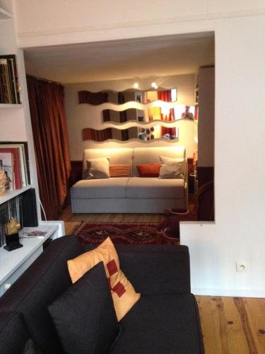 - un salon avec un canapé et une chambre avec une étagère dans l'établissement Dupleix 75m2 sur cour arborée, à Paris