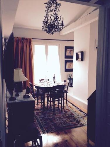 une salle à manger avec une table et des chaises et une fenêtre dans l'établissement Dupleix 75m2 sur cour arborée, à Paris