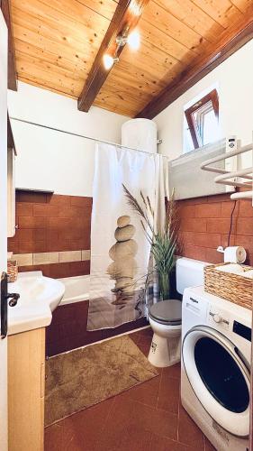 a bathroom with a toilet and a sink and a tub at Kisbattyán Vendégház in Komló