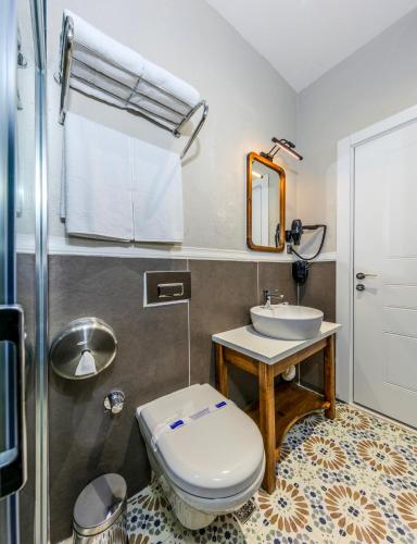 a bathroom with a toilet and a sink at Nenessa Airport Hotel in Arnavutköy