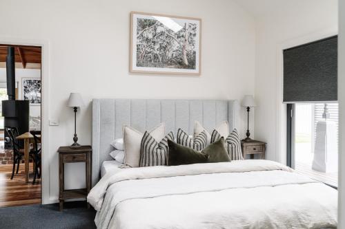 a bedroom with a large white bed with pillows at Athlete's Retreat - 21A Service Street in Porepunkah