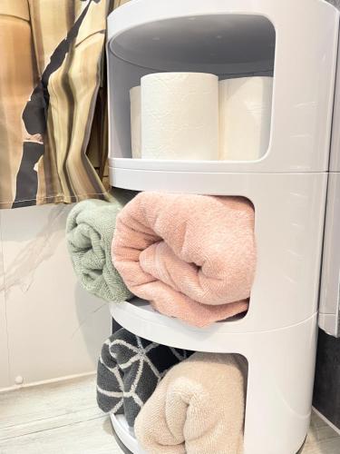 a shelf in a refrigerator filled with towels at Norwich 1st Floor Apartment in Goodmayes