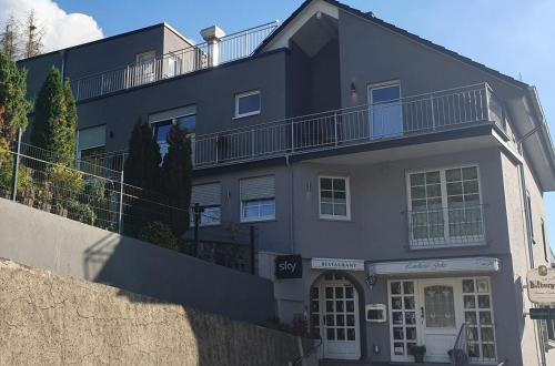 a gray building with a balcony on top of it at Landhotel Gales in Nittel