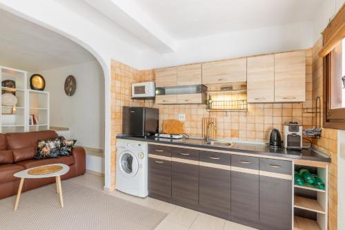 a kitchen with a couch and a washer and dryer at Studio Sillero Dos in Moraira