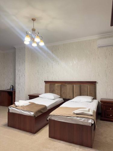 a bedroom with two beds and a chandelier at Golden Kapan in Kapan