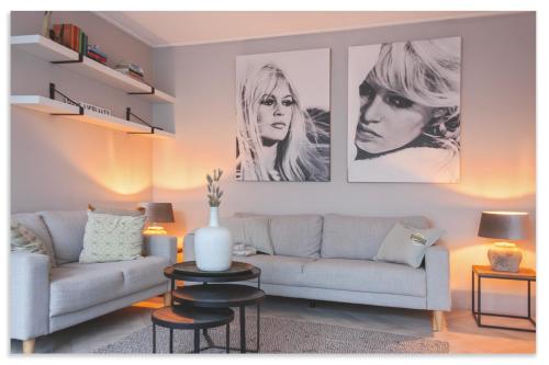a living room with a couch and two pictures on the wall at Cozy Holiday Home with Private Garden at Waterpark in Grou in Grou