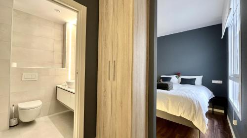 a bedroom with a bed and a bathroom with a toilet at Moderno Piso Céntrico y Equipado in Torrellano