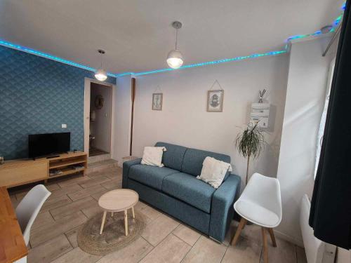 a living room with a couch and a tv at Le Musoir in Le Tréport