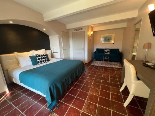 a hotel room with a bed and a desk at Logis Hôtel Restaurant La Bergerie in Aragon