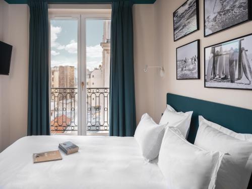 Una cama o camas en una habitación de Hôtel Edgar & Achille