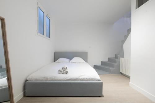 - une chambre blanche avec un lit et un escalier dans l'établissement Majestic Suites - Paris 11, à Paris