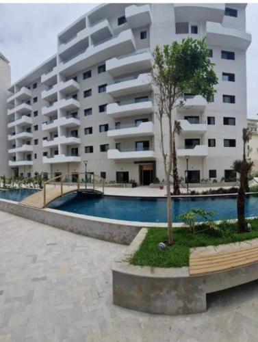a large apartment building with a pool in front of it at Beautiful apartment in the heart of Zenata in Aïn Harrouda