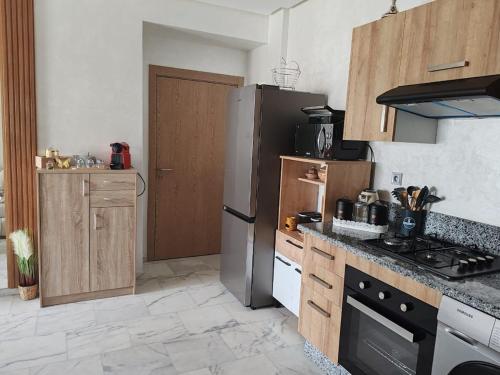a kitchen with a refrigerator and a stove top oven at Beautiful apartment in the heart of Zenata in Aïn Harrouda