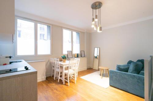 un salon avec un canapé bleu et une table dans l'établissement Majestic Suites - Paris 11, à Paris