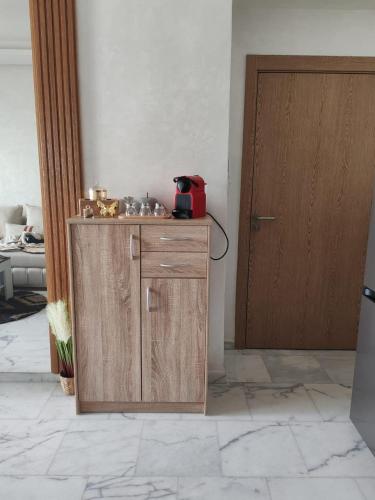 a room with a wooden cabinet with a red telephone at Beautiful apartment in the heart of Zenata in Aïn Harrouda