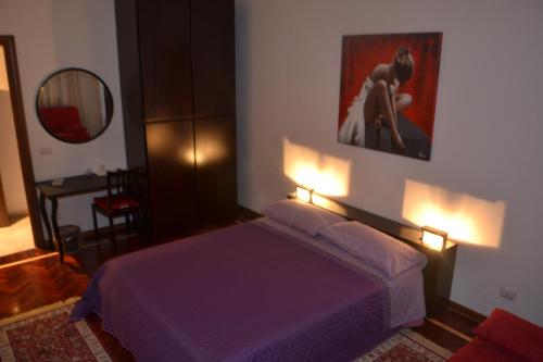a bedroom with a purple bed and a mirror at B&B Visconti in Lido di Ostia