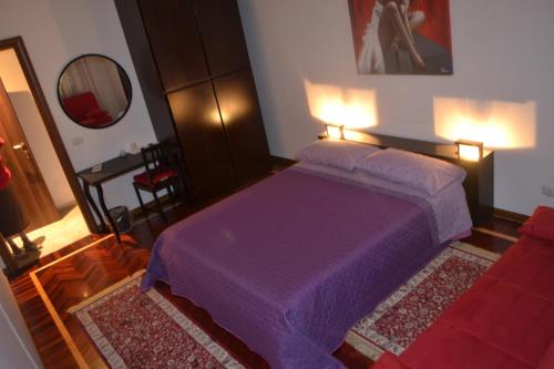 a bedroom with a purple bed and a mirror at B&B Visconti in Lido di Ostia