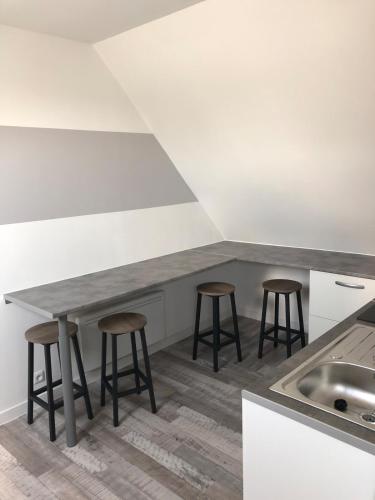 une cuisine avec une table et quatre tabourets dans l'établissement Quiet studio, à Saint-Mars-sous-Ballon