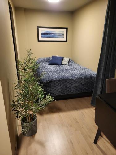トロムソにあるModern Studio Apartment in the Heart of Tromsøのベッドと鉢植えのある寝室