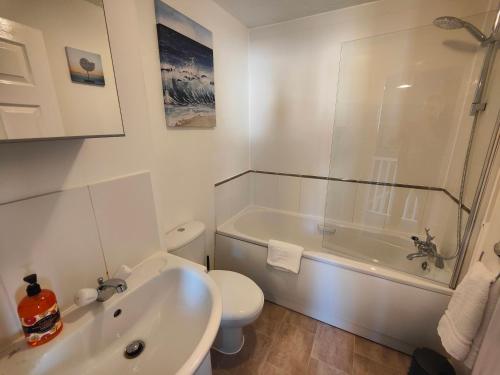 a bathroom with a tub and a toilet and a sink at Cedar - AwayOnBusiness in Eastleigh
