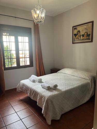 a bedroom with a bed with towels on it at Casa Puente ROMANO cerca de Sevilla in Alcalá de Guadaira