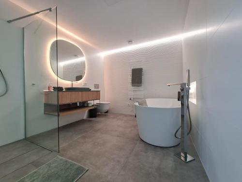 a bathroom with a tub and a sink and a mirror at Villa Benimaurell Relax Beach Moraira in Moraira