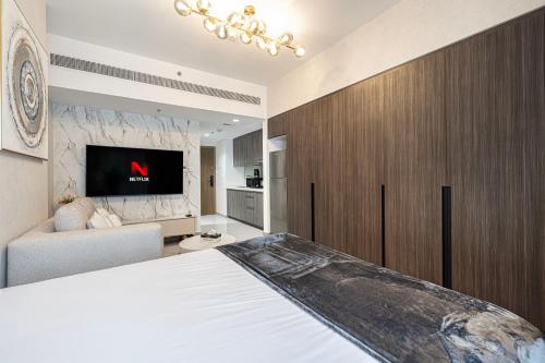 a bedroom with a large white bed and a tv at شقة استوديو فاخرة في الزاهية الشارقة - cozy Studio in Sharjah