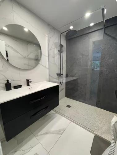 une salle de bain avec un lavabo et une douche avec un miroir dans l'établissement Oasis by L'Oliveraie, à Cannes