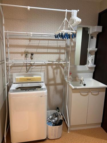a small kitchen with a sink and a washing machine at Sin-imamiya House in Osaka
