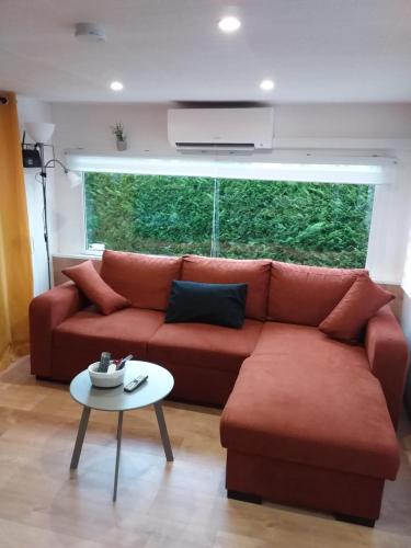 un salon avec un canapé rouge et une table dans l'établissement Camping La Lande, à Mimizan