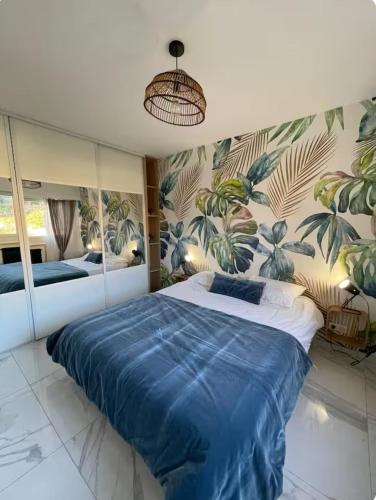 une chambre avec un grand lit avec une couette bleue dans l'établissement Oasis by L'Oliveraie, à Cannes