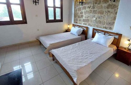 two beds in a room with two windows at Saint Michel Hotel in Rhodes Town