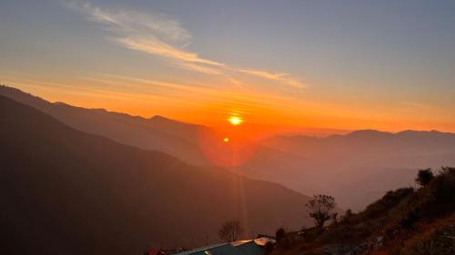 a view of the sun setting over the mountains at Wander Thrives iNN in Manāli