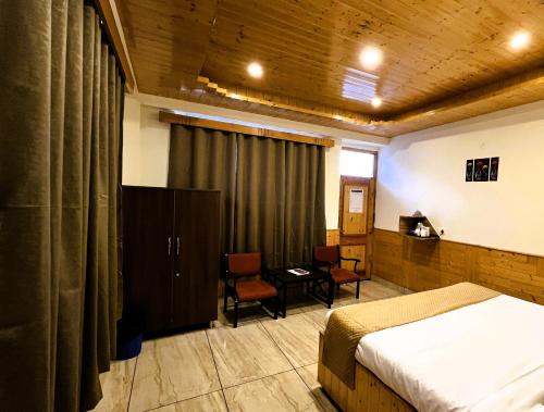 a bedroom with a bed and a table and chairs at Wander Thrives iNN in Manāli