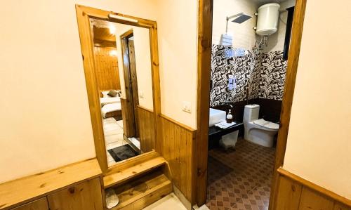 a bathroom with a mirror and a toilet at Wander Thrives iNN in Manāli
