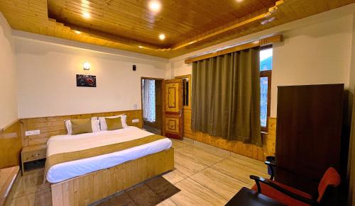 a bedroom with a bed and a desk and a chair at Wander Thrives iNN in Manāli