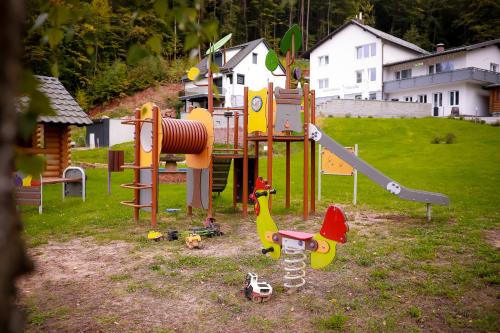 a park with a playground with toys in the grass at Main Spessart Terrasse Hotel in Gemünden