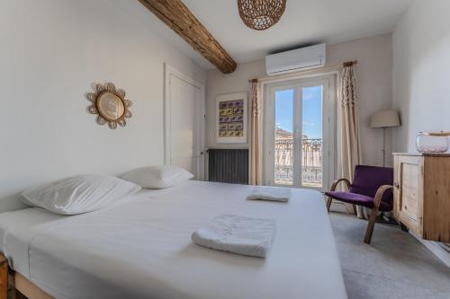 une chambre blanche avec un grand lit et une fenêtre dans l'établissement Charmant T4 en plein cœur de Montpellier, à Montpellier