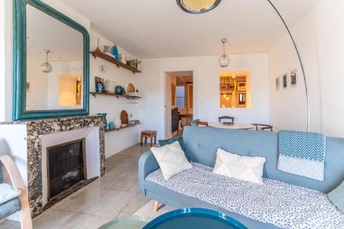 un salon avec un canapé bleu et une cheminée dans l'établissement Charmant T4 en plein cœur de Montpellier, à Montpellier