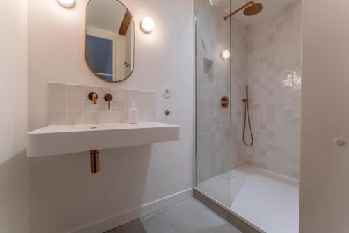 une salle de bain blanche avec un lavabo et une douche dans l'établissement Charmant T4 en plein cœur de Montpellier, à Montpellier