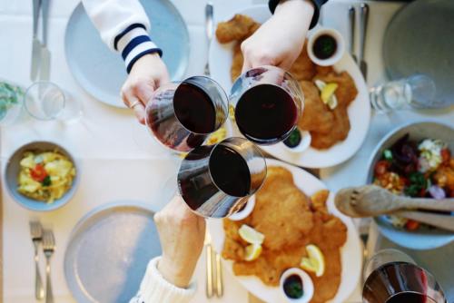 two people are holding glasses of wine on a table at Sonnmatten Boutique Hotel & Apartments Zermatt in Zermatt
