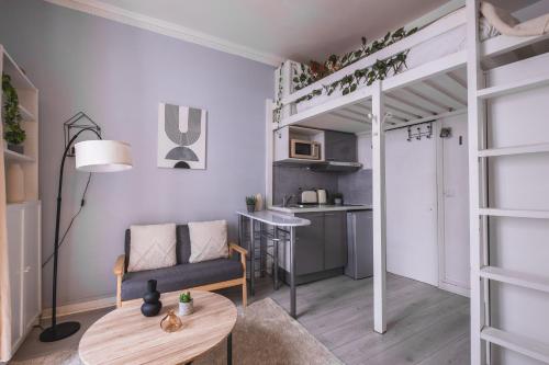 Ce petit appartement comprend une mezzanine et une table. dans l'établissement Charmant studio au cœur du 16ᵉ, à Paris