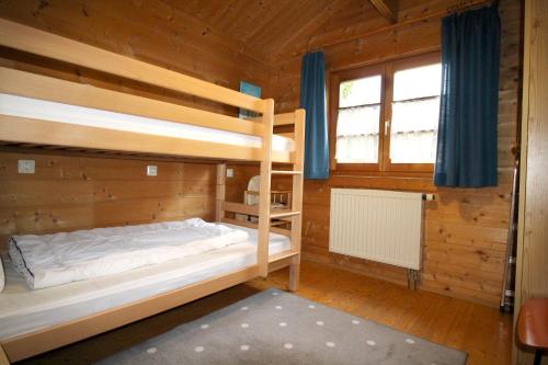 a bedroom with bunk beds in a wooden cabin at Ferienhaus Donau 31 Glückskäfer in Hayingen